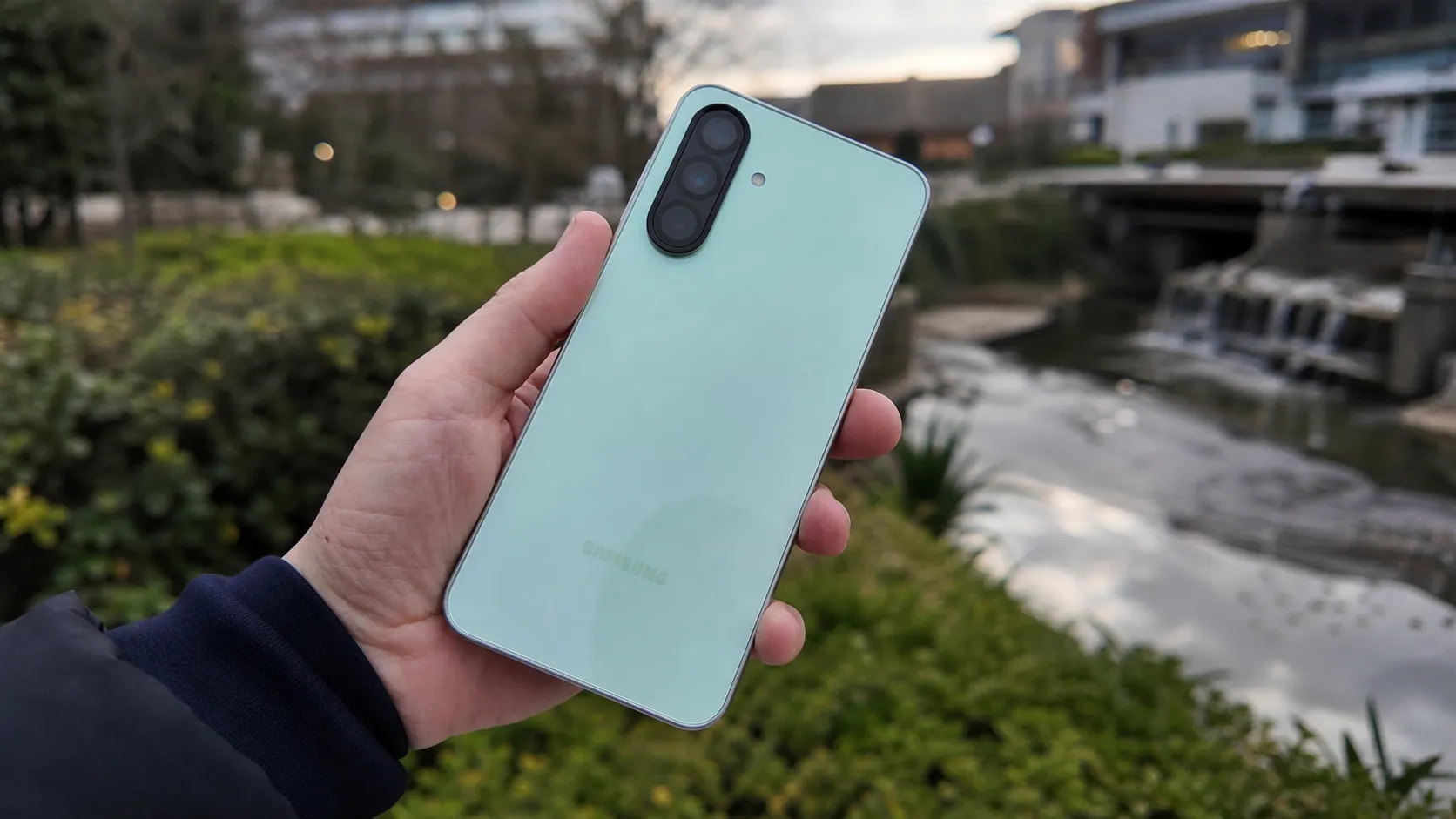 Hand holding Samsung Galaxy A36 mint green while One UI 9 Android 17 update rolls out